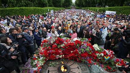 Участники акции Бессмертный полк возлагают цветы к Вечному огню в киевском парке Славы
