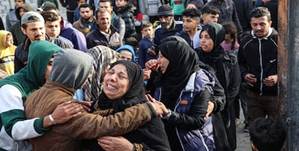 Le donne si consolano a vicenda dopo la distruzione delle case in un attacco aereo israeliano a Rafah. AFP
