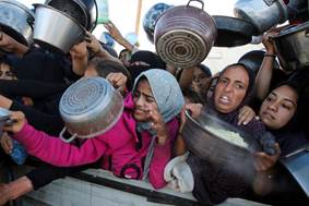 I palestinesi si riuniscono per ricevere cibo cucinato da una cucina di beneficenza, nel mezzo di una crisi di fame, mentre continua il conflitto tra Israele e Gaza, a Khan Younis nella Striscia di Gaza meridionale, 19 novembre 2024. REUTERS/Hatem Khaled IMMAGINI TPX DEL GIORNO