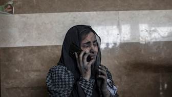 An injured woman on the phone at Nasser Hospital in Khan Younis. EPA