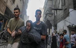 Una donna ferita � stata aiutata a lasciare il campo profughi di Al Shati dopo un attacco missilistico israeliano. EPA