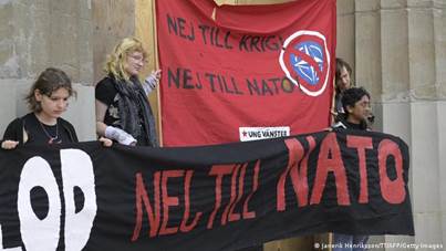 I manifestanti tengono cartelli a Stoccolma che condannano la decisione della Svezia di aderire alla NATO.